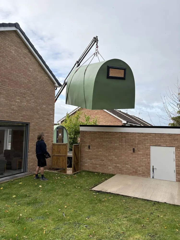Andrew's Skipjack Glass Pod being craned over the house into the garden