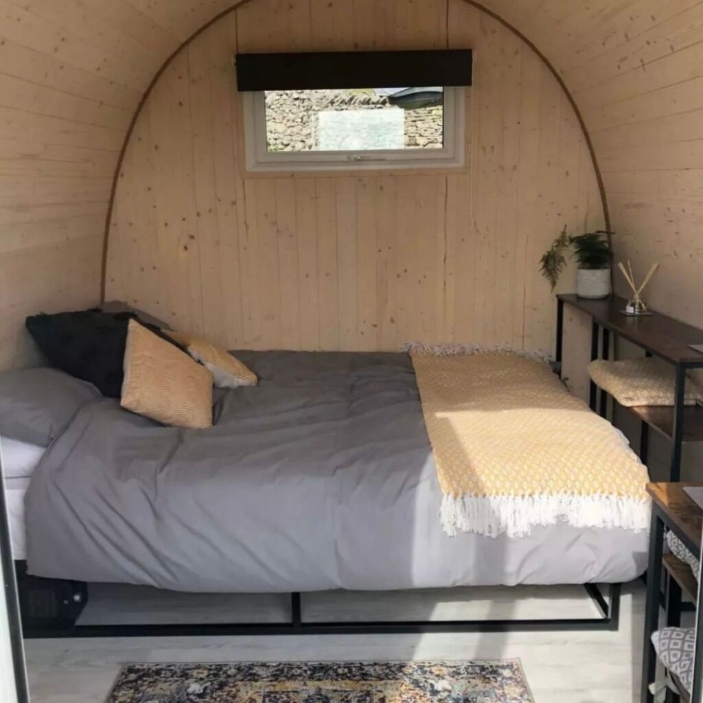 Starting a Glamping Business: Standard Campsite Size Outdoor Pods | Glamping Pod with wood paneling and cosy bed