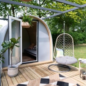 Starting a Glamping Business: Standard Campsite Size Outdoor Pods | Image Description: Porch of grey outdoor Pod featuring egg chair swing